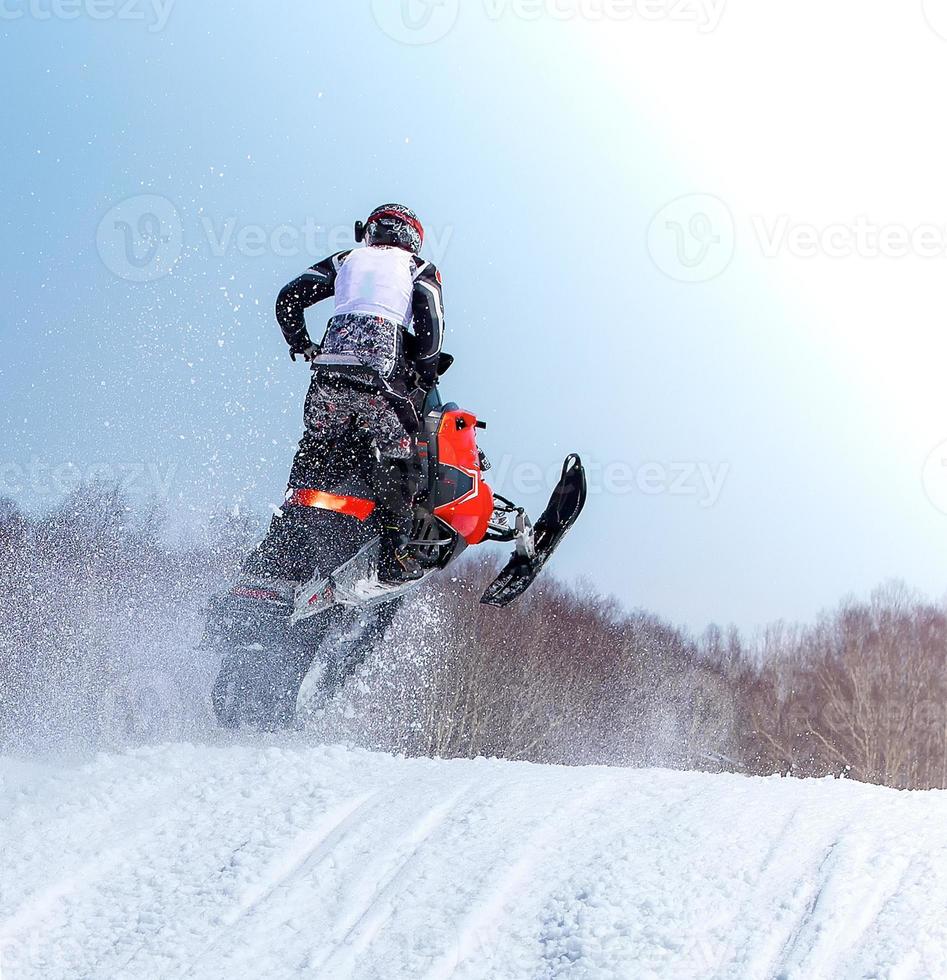 Snowmobile in high jump above track. Selective focus photo