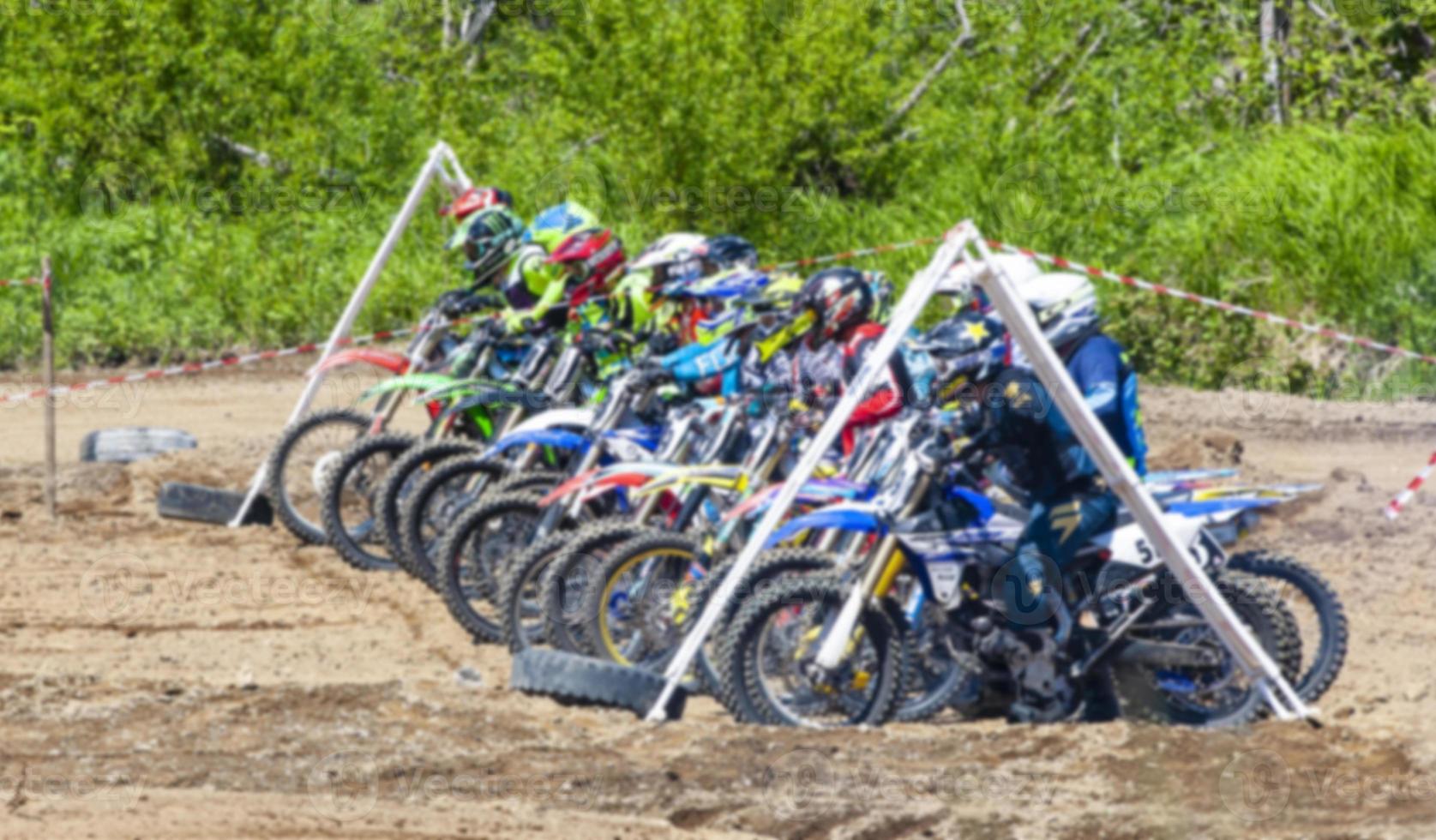 Motocross riders practice tricks on their dirt bikes on a sunny day photo