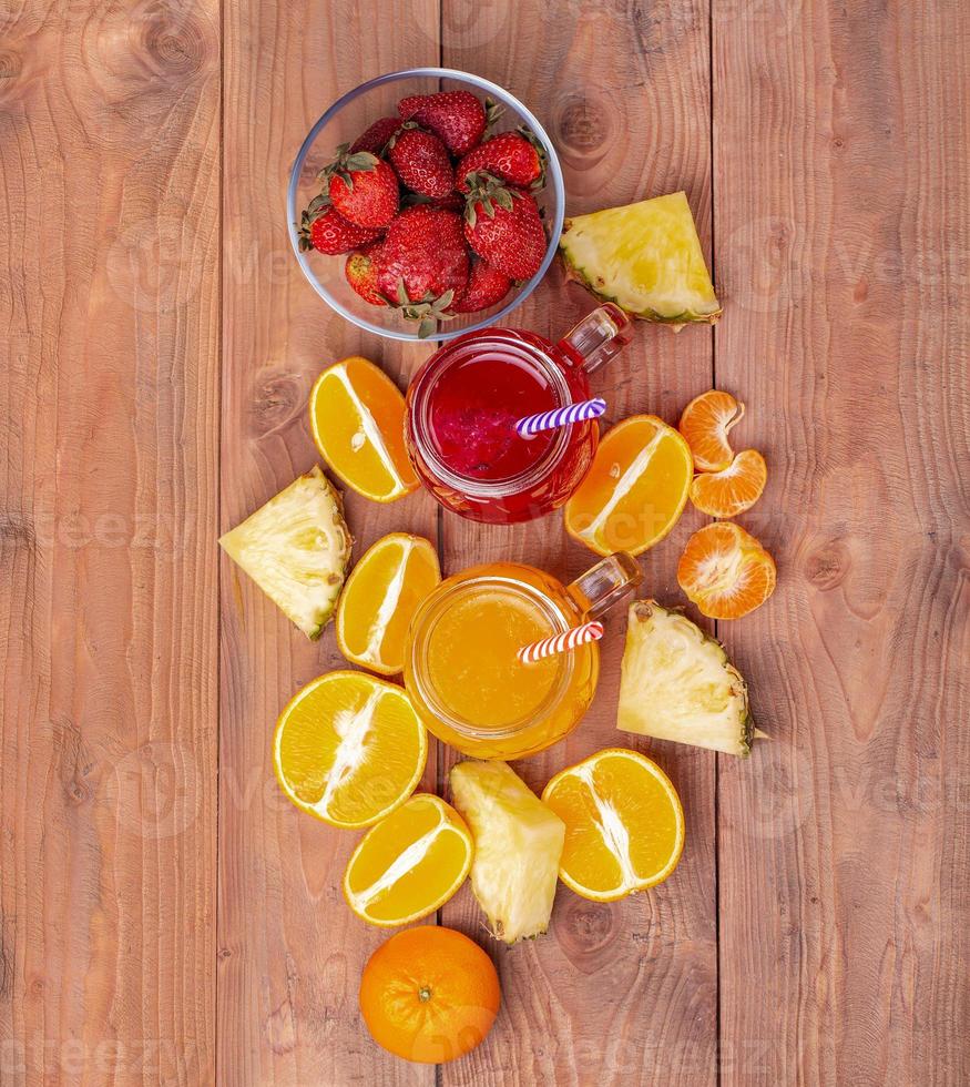 The Fresh strawberry and orange cocktailes with fruits on a wooden rustic background. Freshly blended summer smoothie nice to drink during a hot day. photo