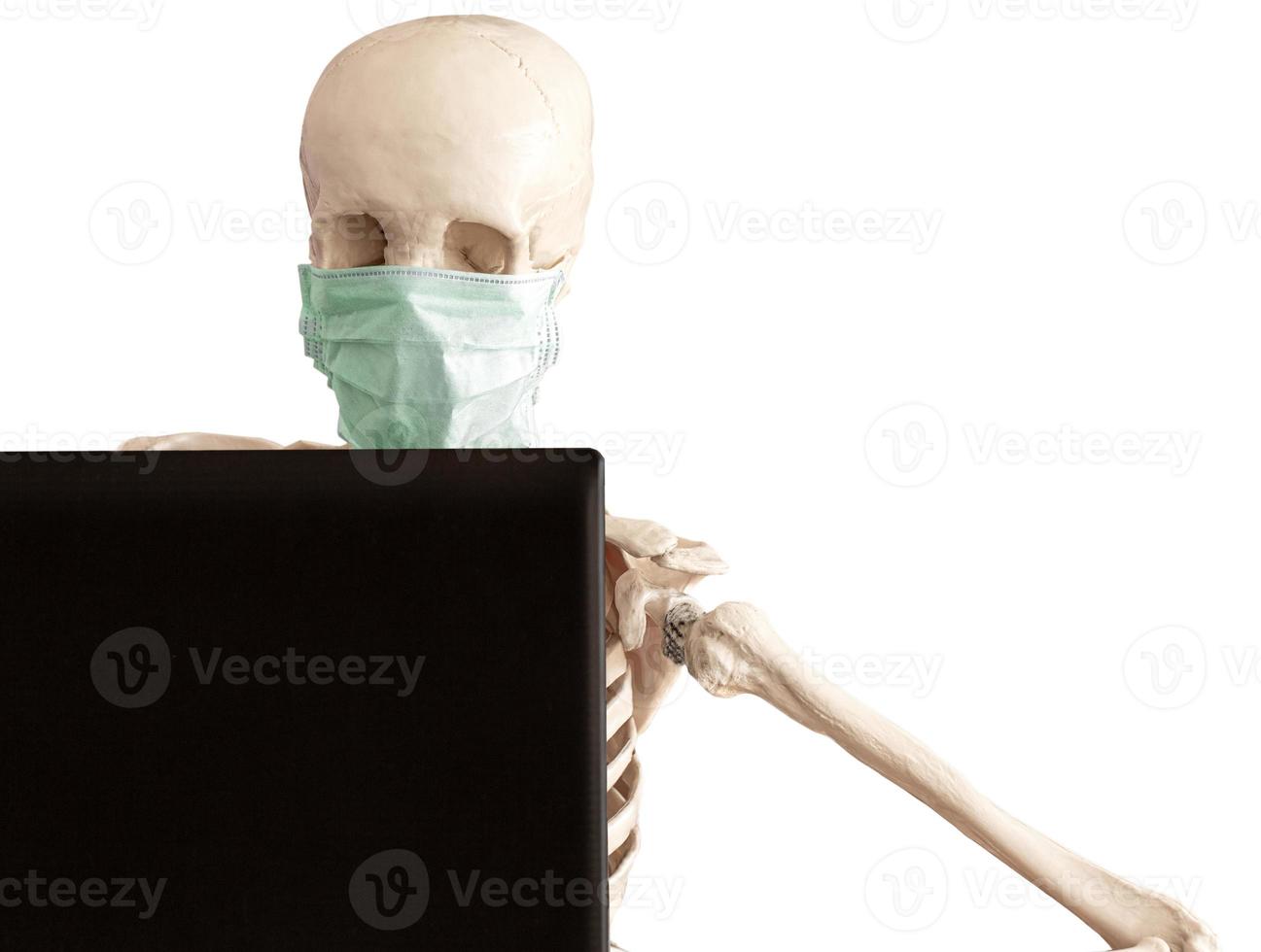 skeleton in protective medical mask works with the laptop photo