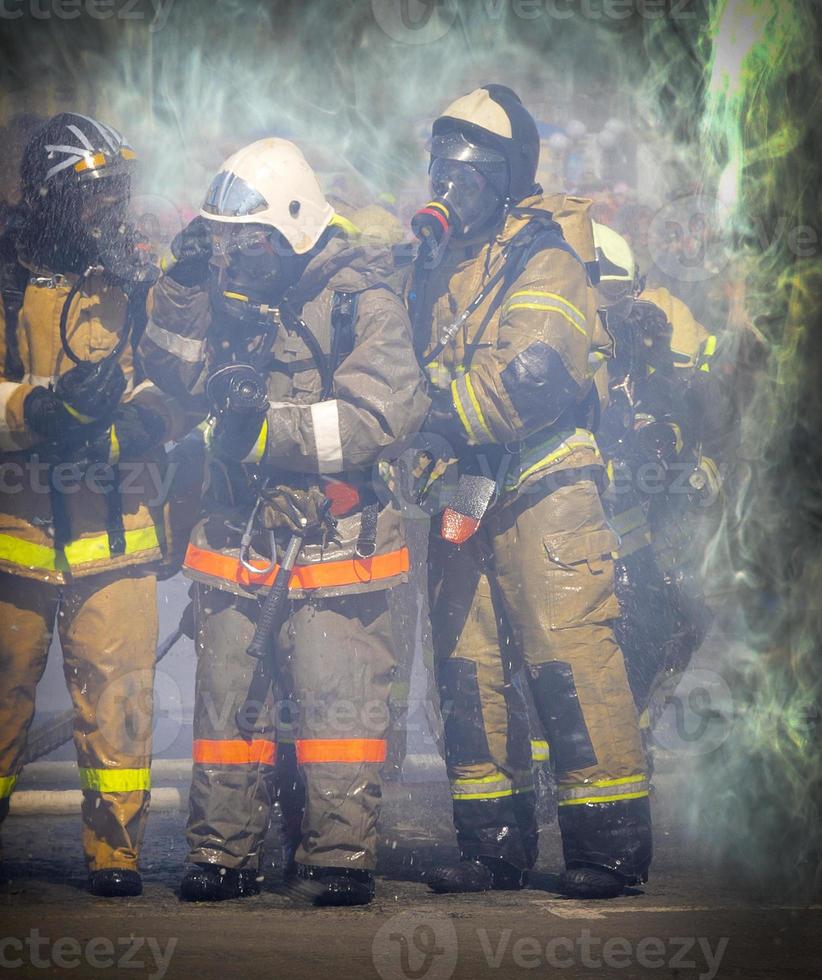 The group of firefighters fighting a fire photo