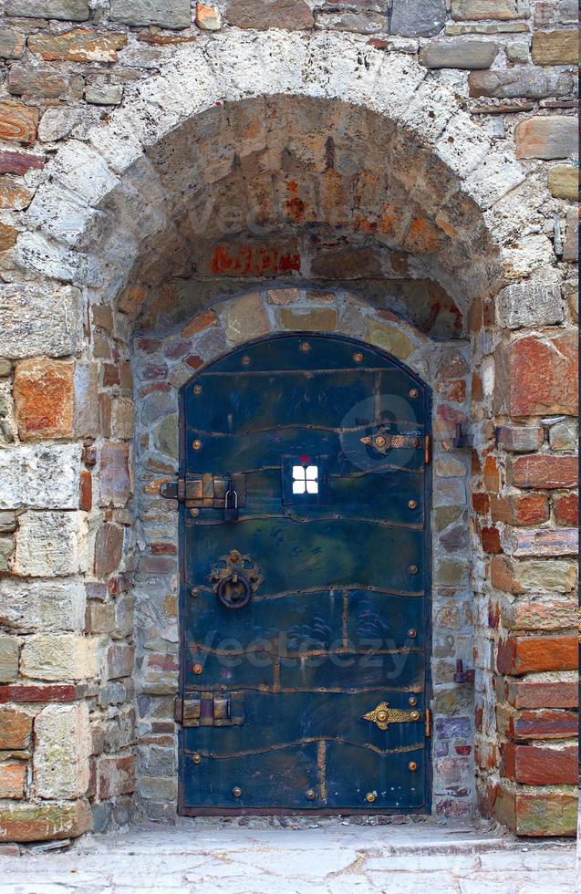antigua puerta de metal con mampostería de piedra con cerradura foto