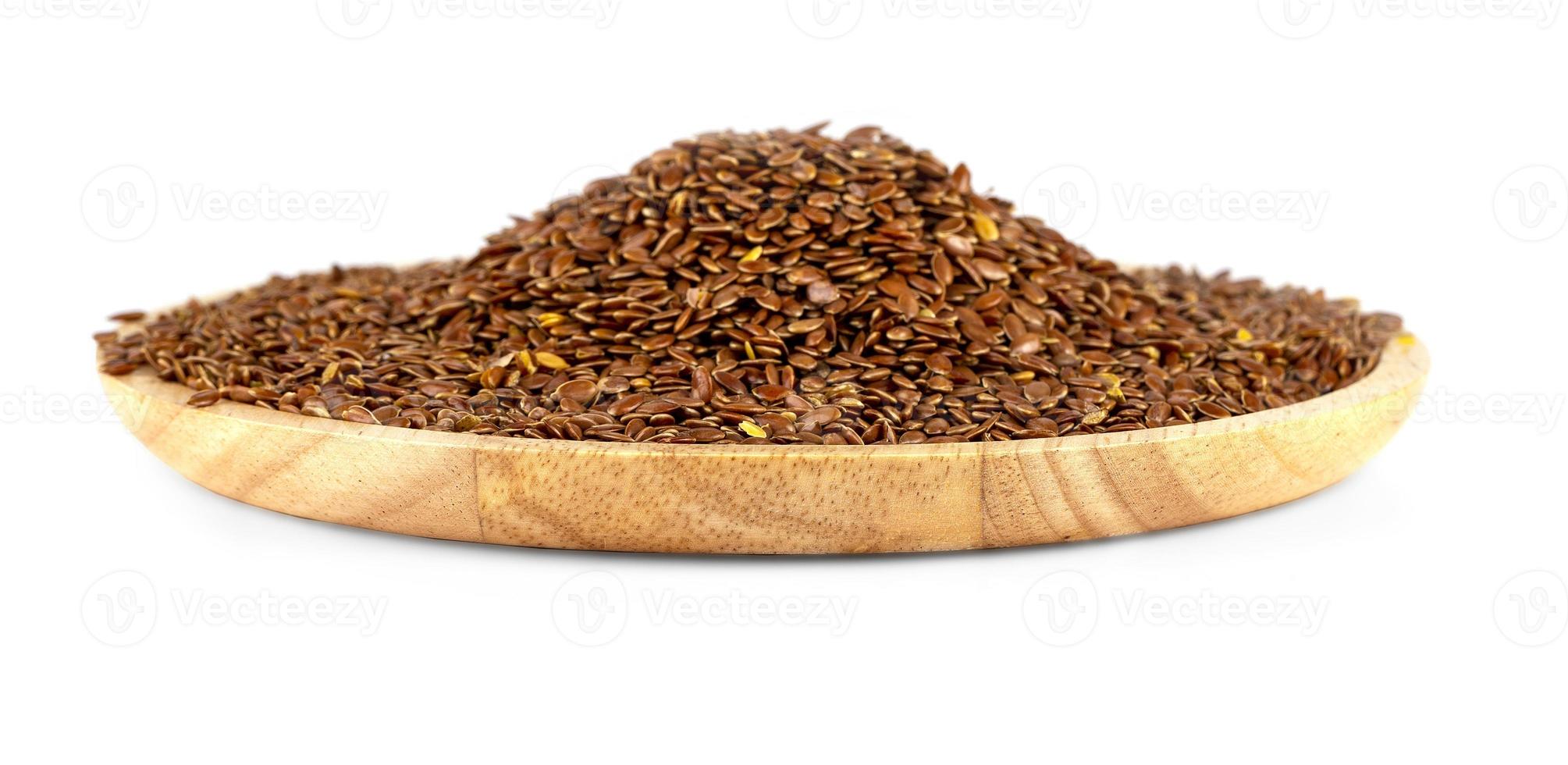 The Flax seeds in a wooden plate isolated on a white background photo