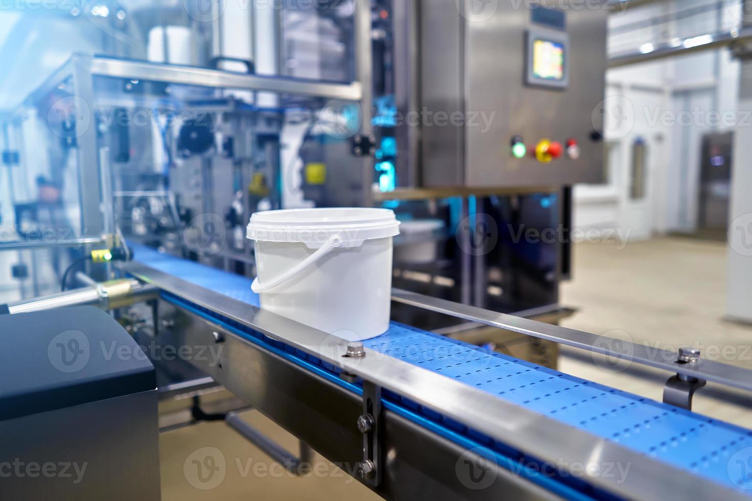 bucket with finished products on the conveyor of a food enterprise photo