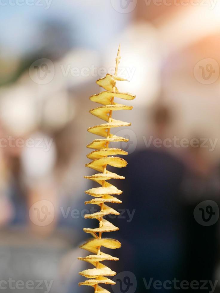 potato chips on a wooden stick deep fried photo