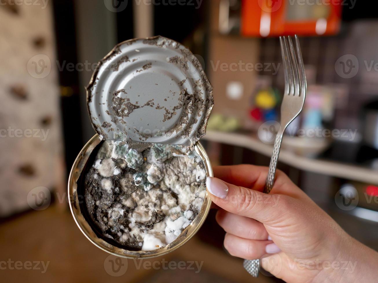 expired canned fish in woman's hand close-up photo