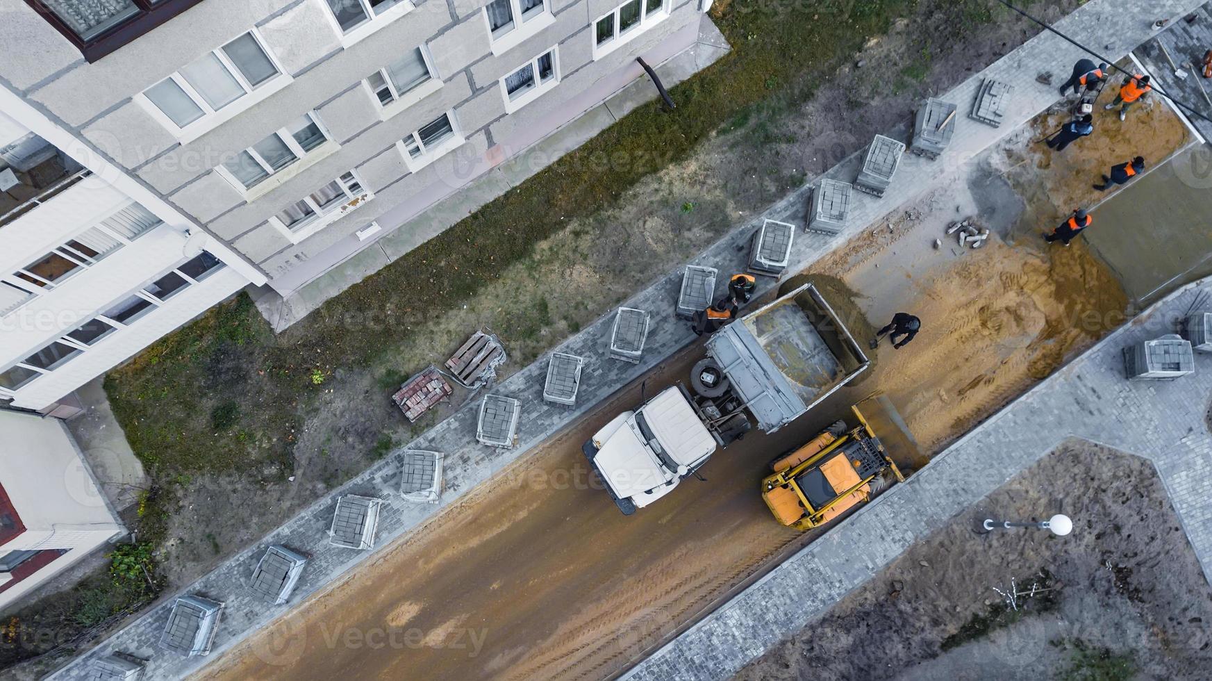 laying of paving slabs on the prepared concrete surface. Repair of the pedestrian walkway in the city. urban municipal work photo