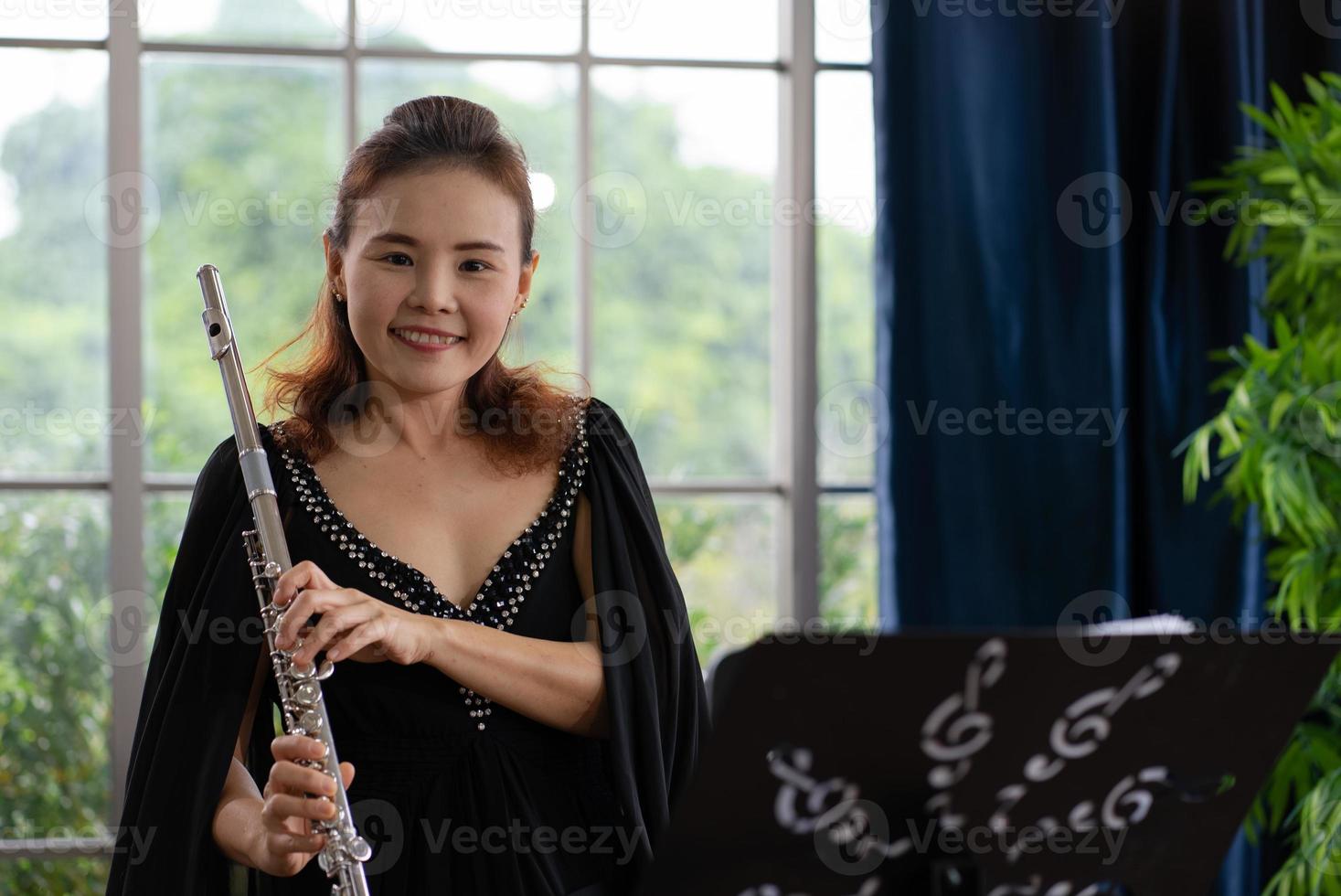 portrait of musician playing flute in room photo