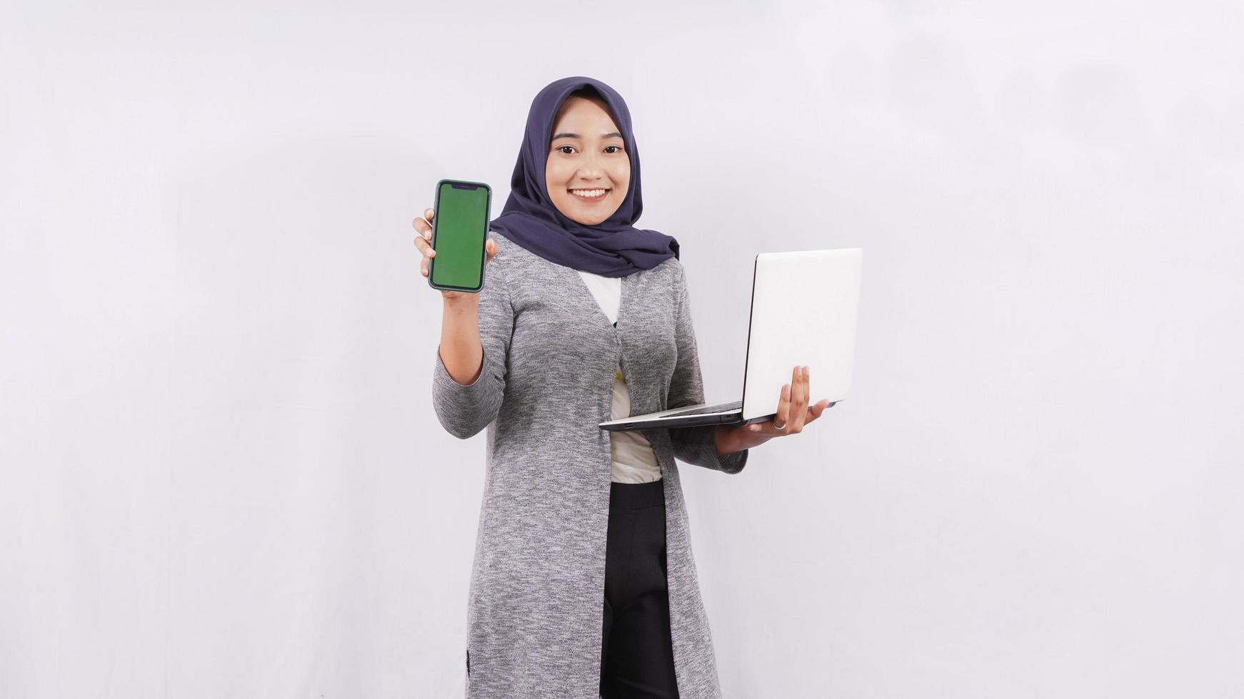 asian girl opening laptop showing smartphone screen isolated on white background photo