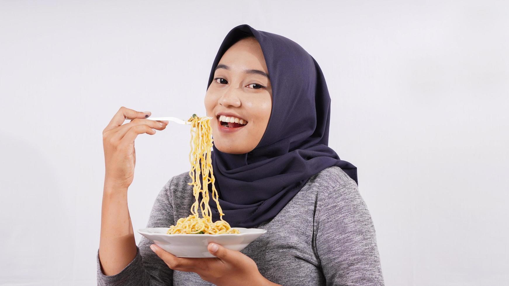 asian girl happily enjoying noodles isolated on white background photo