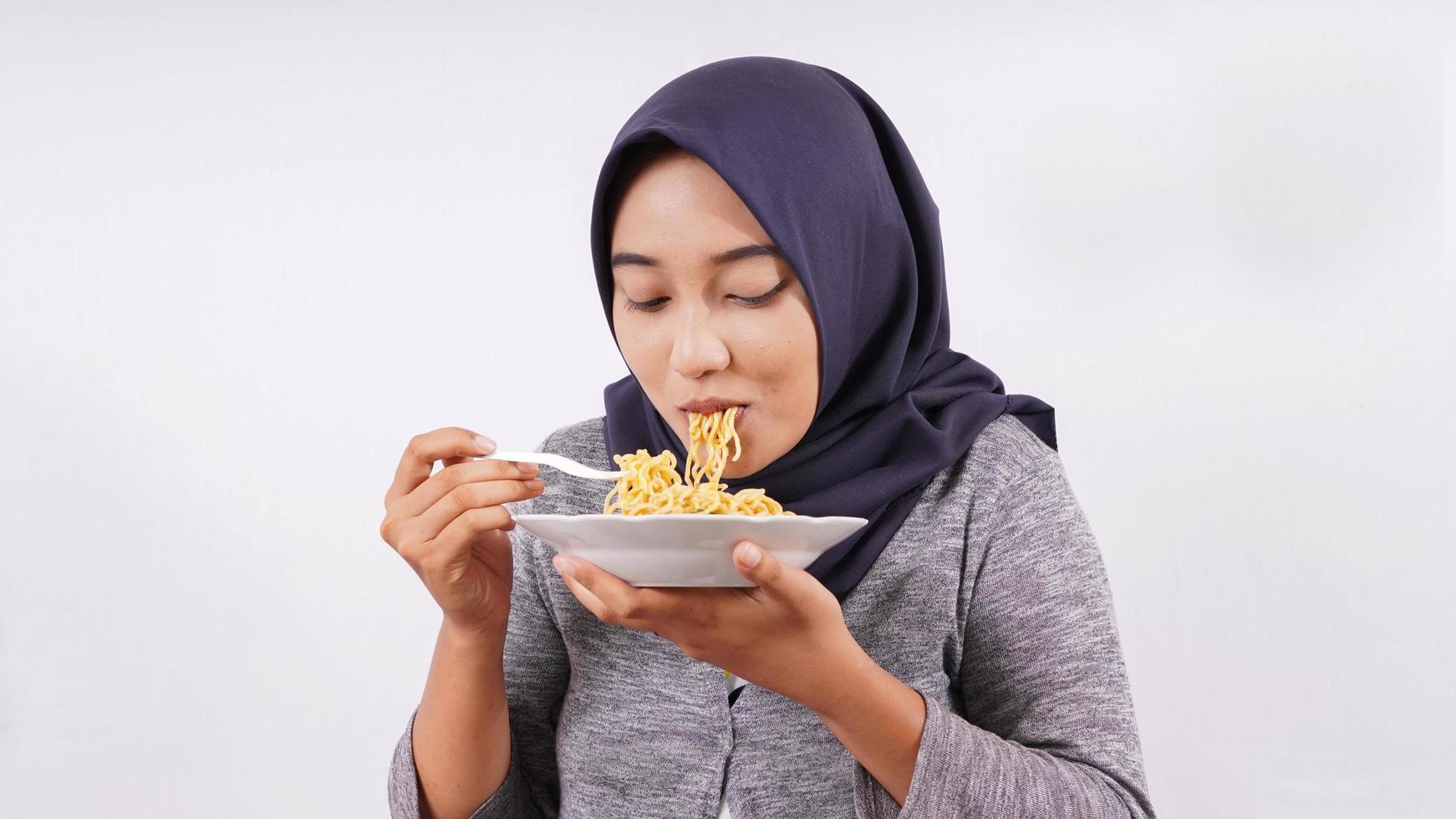 asian girl happily enjoying noodles isolated on white background photo