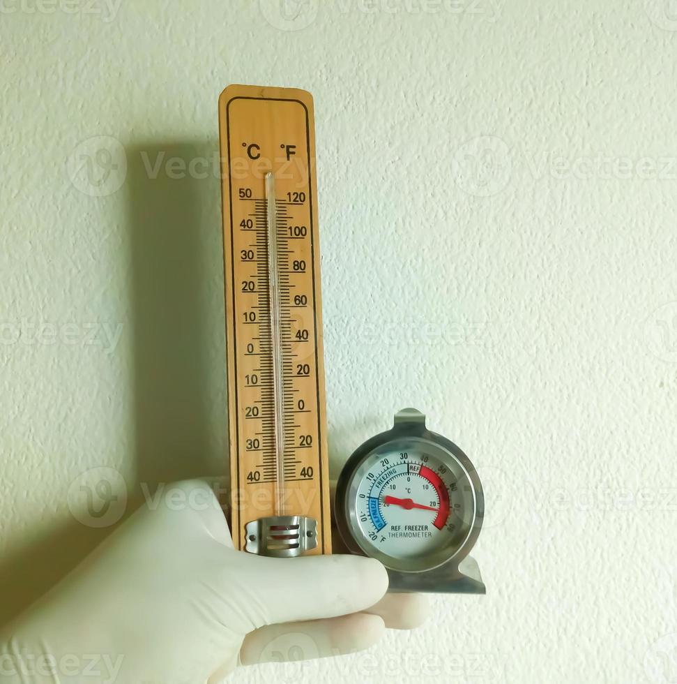 Gloved hand hold analog and digital fridge thermometer to monitoring laboratory temperature, Thermal detector photo