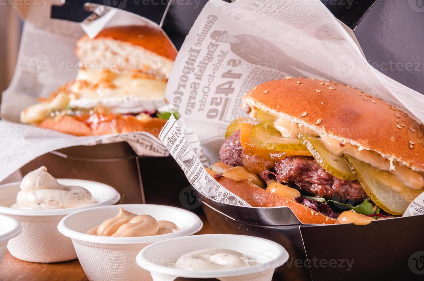 Burgers and dip sauces in takeaway containers. Fast food delivery concept photo