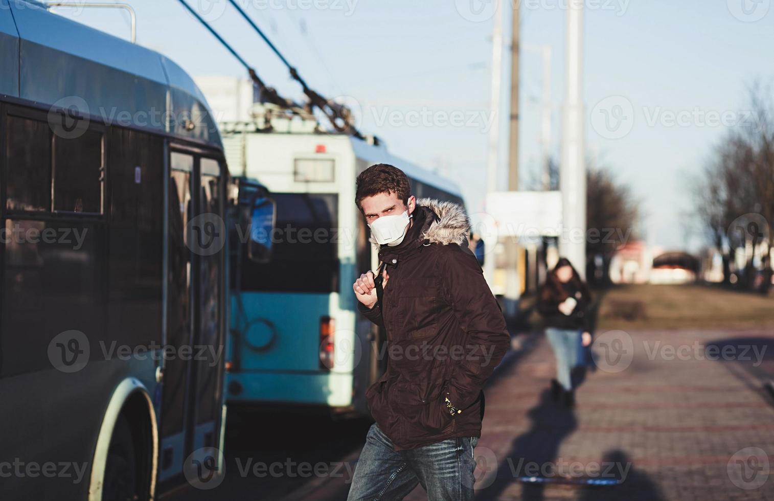 People wearing surgical mask standing at the bus stop photo