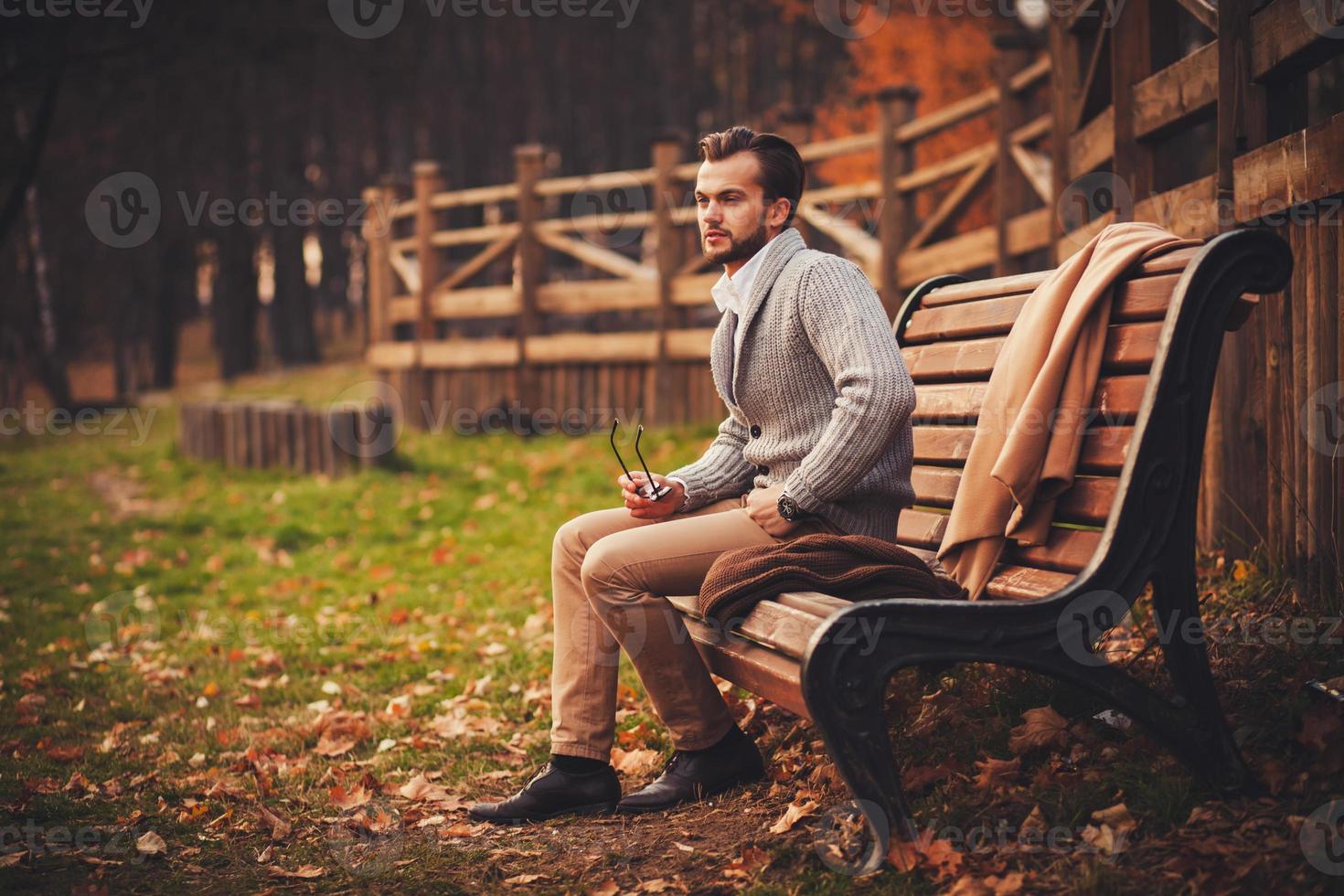 handsome man sitting in bench photo