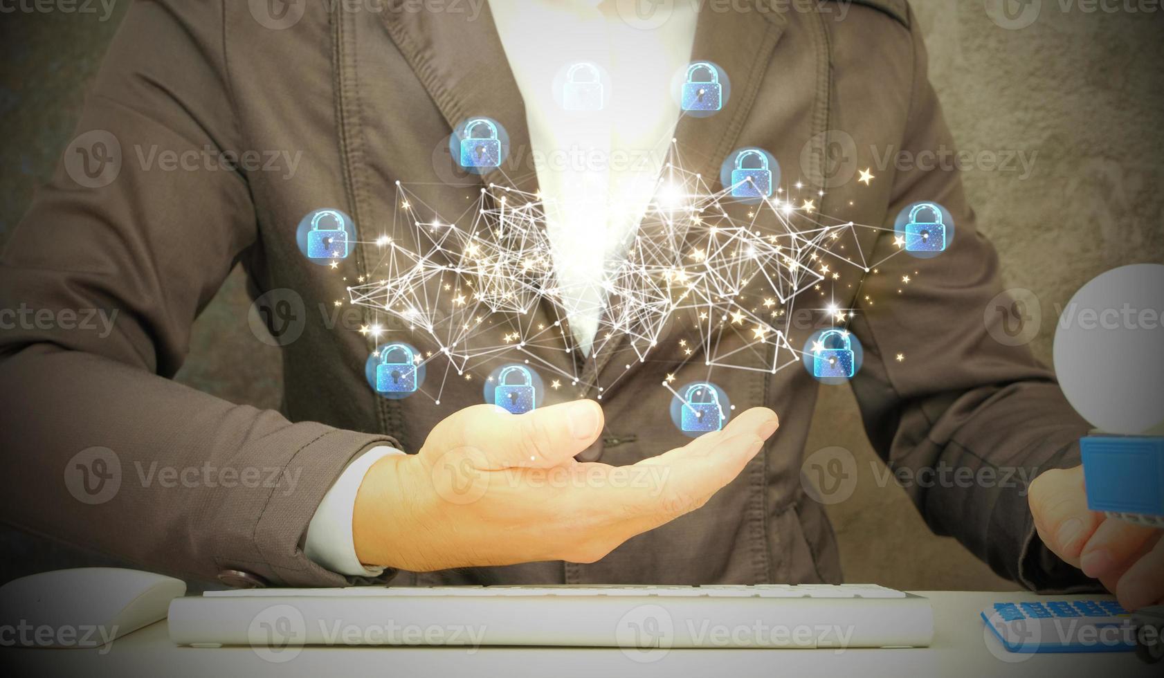 Hands working on a computer and a lock holographic drawing are both double-exposed. Concept of security. photo