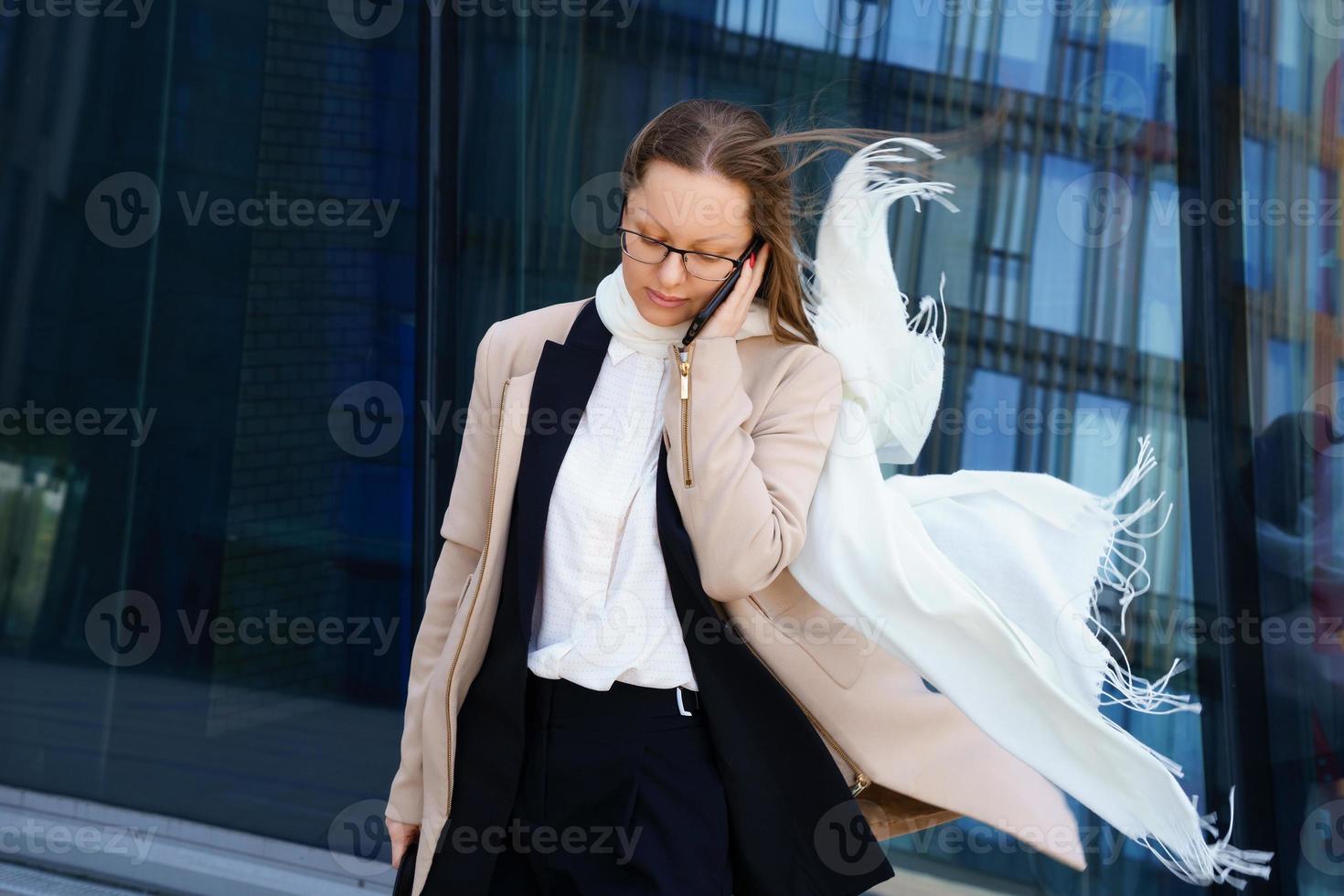 mujer de negocios con gafas y un traje está hablando por teléfono foto