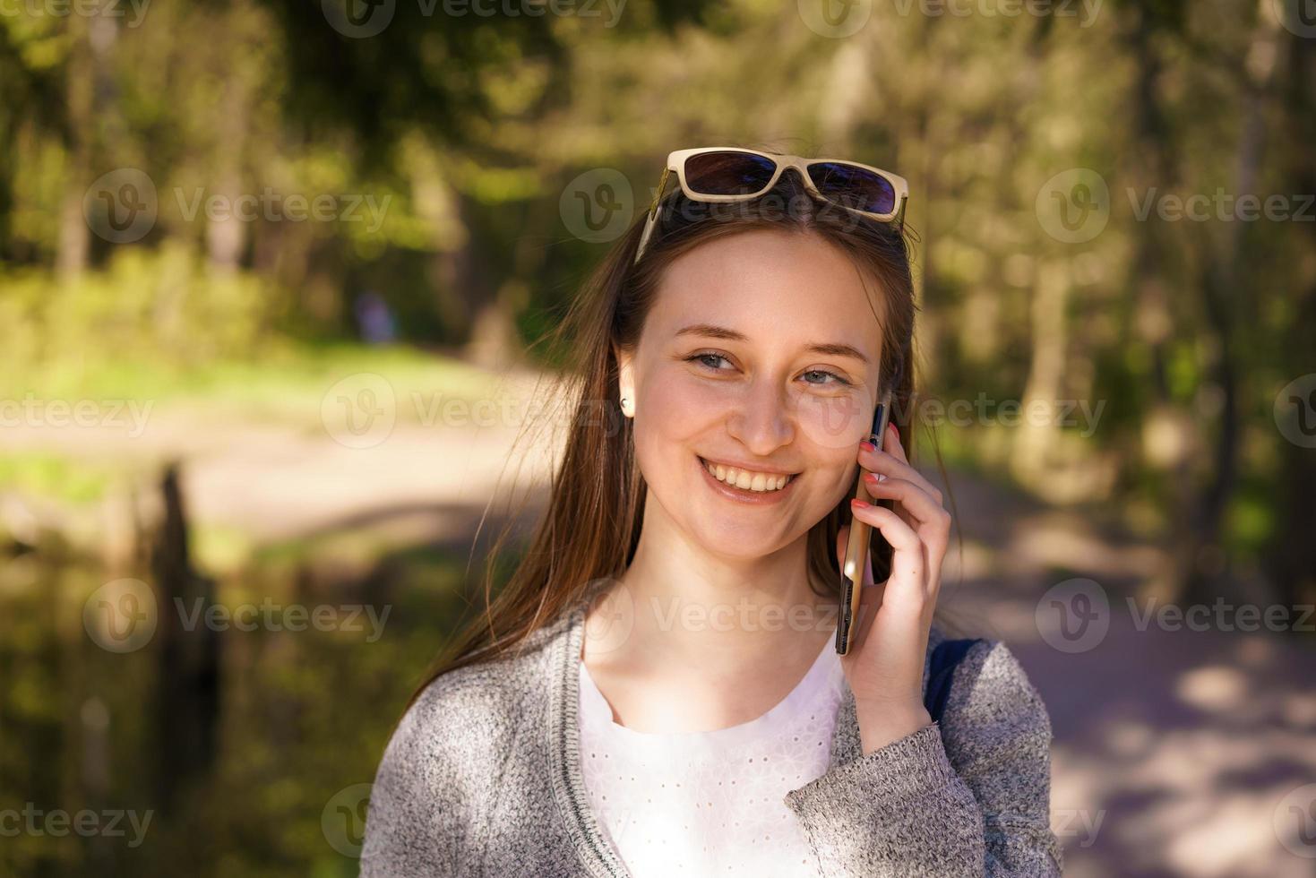 a girl walks and talks on the phone on a sunny spring day photo