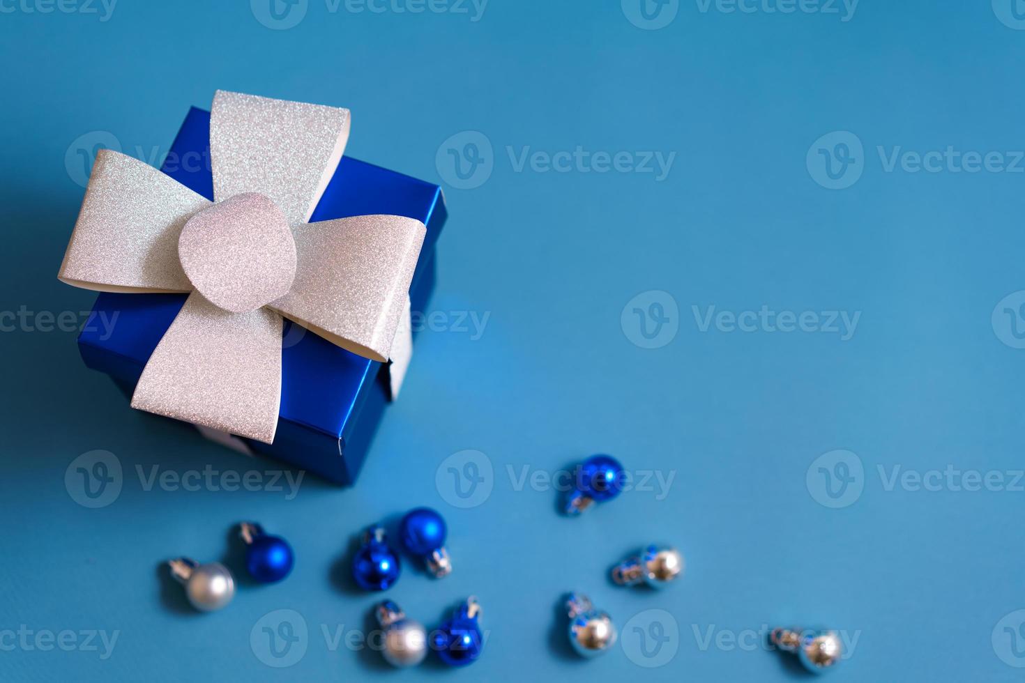 blue gift box with christmas balls on blue background photo