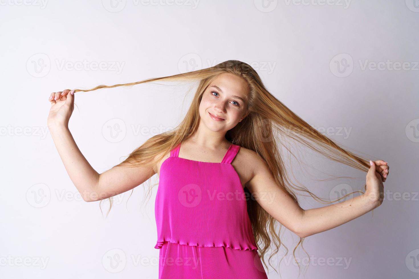 Cute girl on a white background plays with hair photo