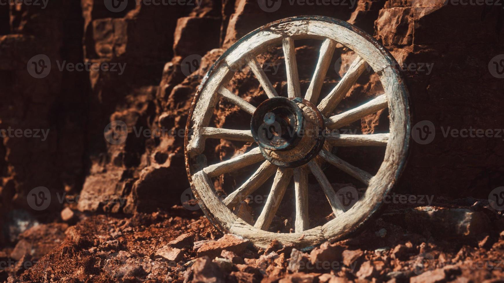 rueda de carreta de madera antigua sobre rocas de piedra foto