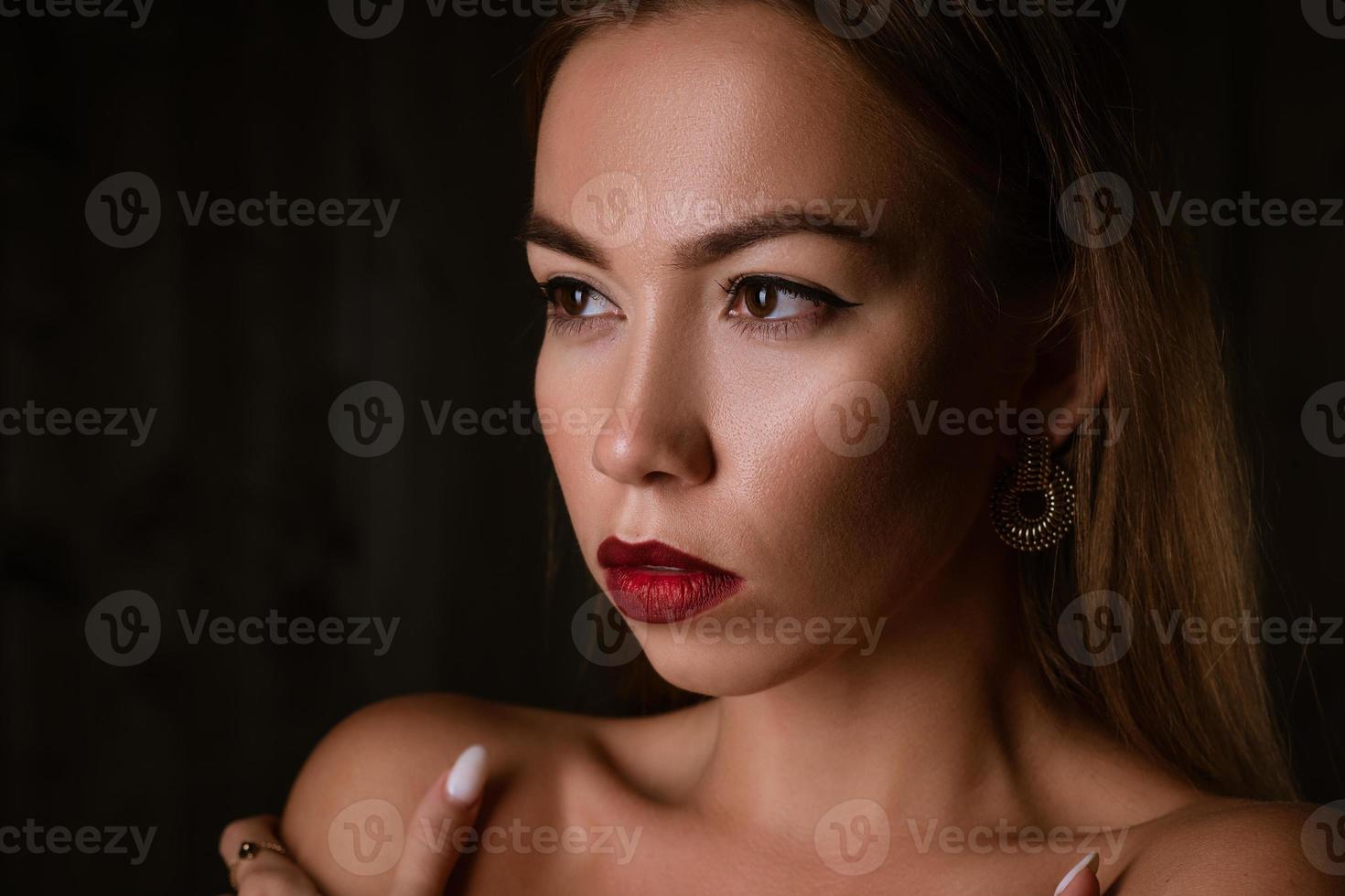 retrato de una hermosa morena con labios pintados de fondo negro foto