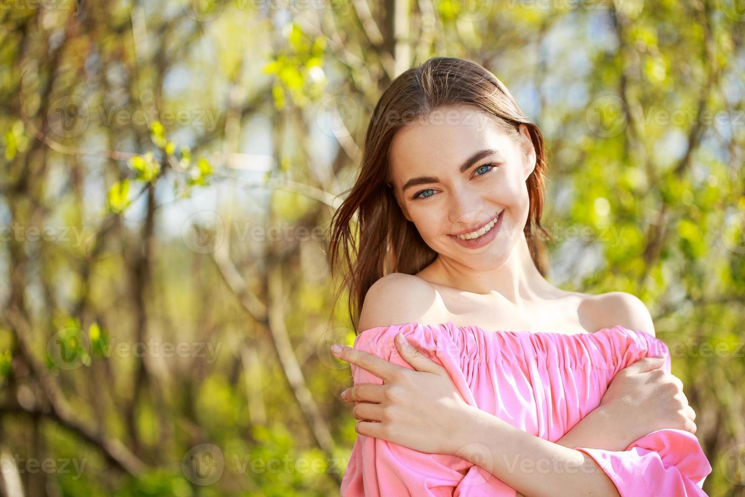 Portrait of a beautiful young woman on a natural background smiling photo