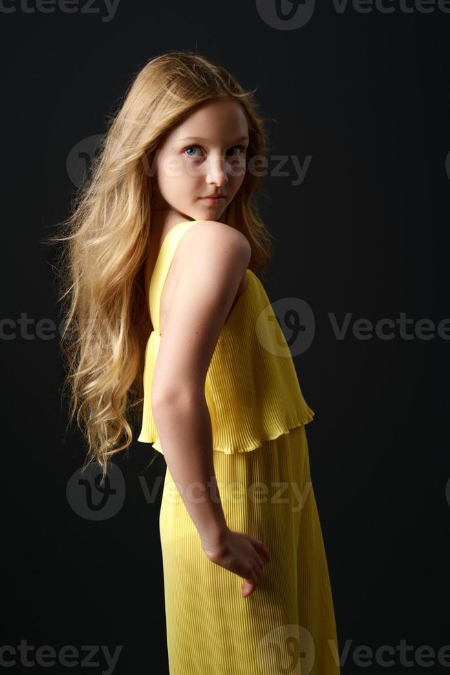 girl  yellow clothes posing on a black background photo