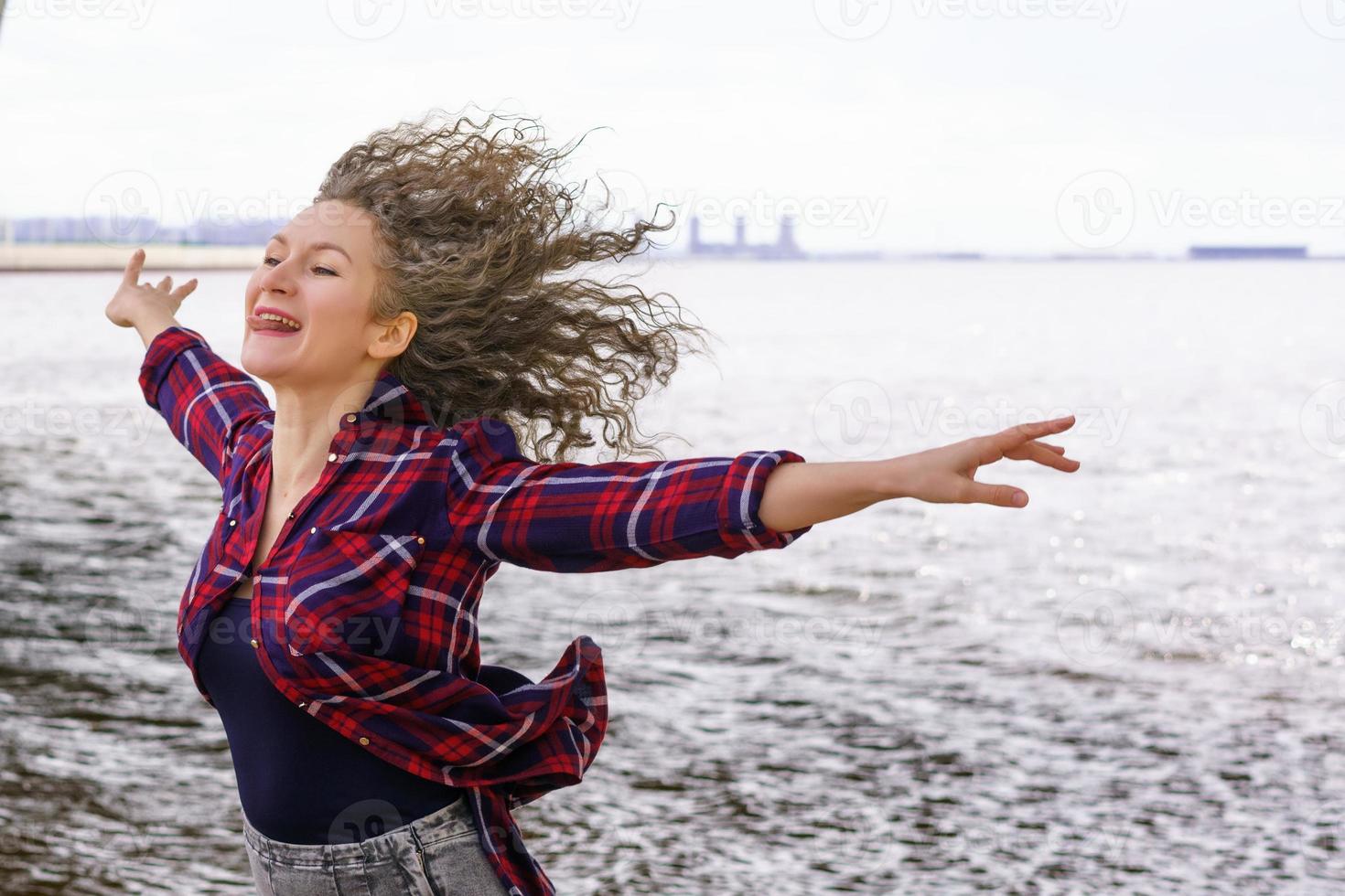 mujer con los brazos extendidos hacia un lado contra el fondo del agua foto