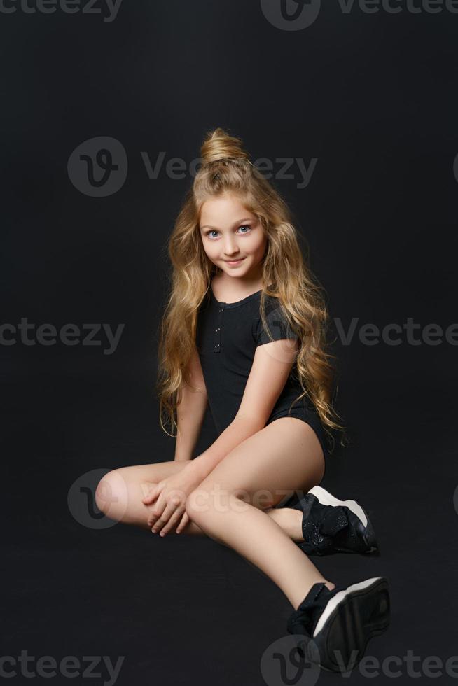 girl in a black bodysuit on a black background photo