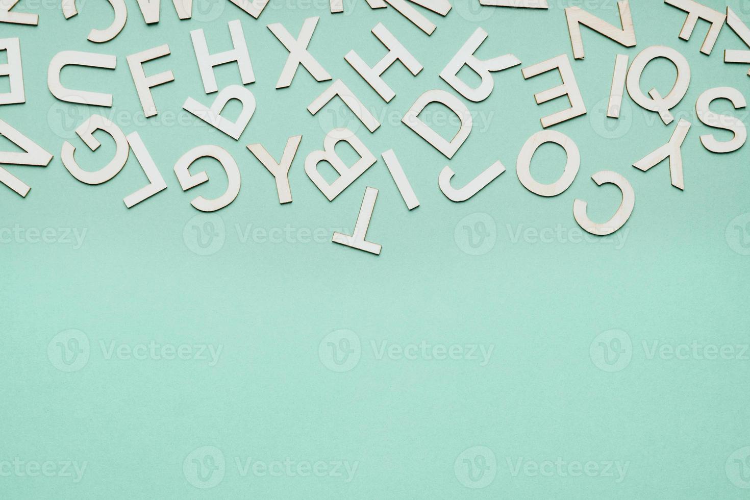 jumble of wooden letters falling down on blue paper background photo