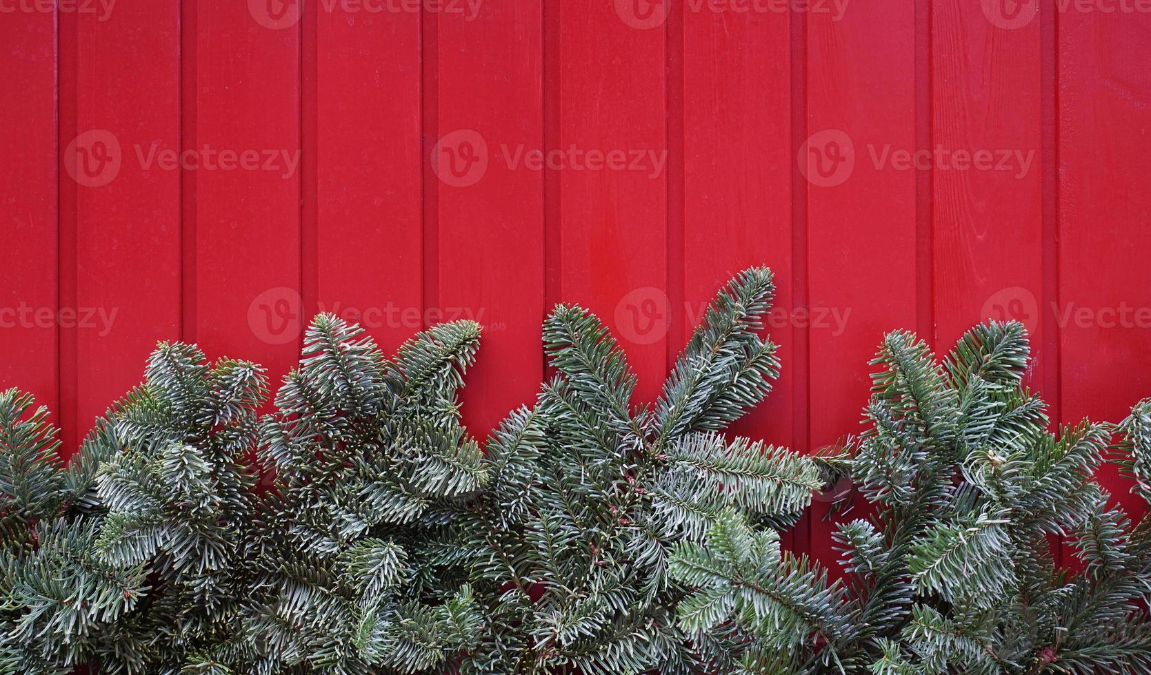 fondo de navidad con madera roja y ramitas de abeto verde foto