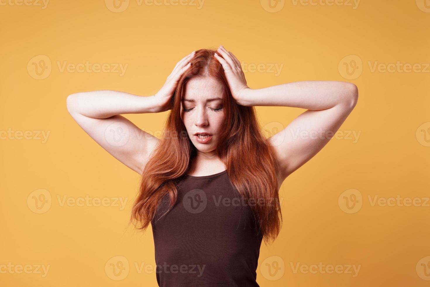 mujer joven agotada estresada sosteniendo la cabeza que sufre de dolor de cabeza o crisis nerviosa foto