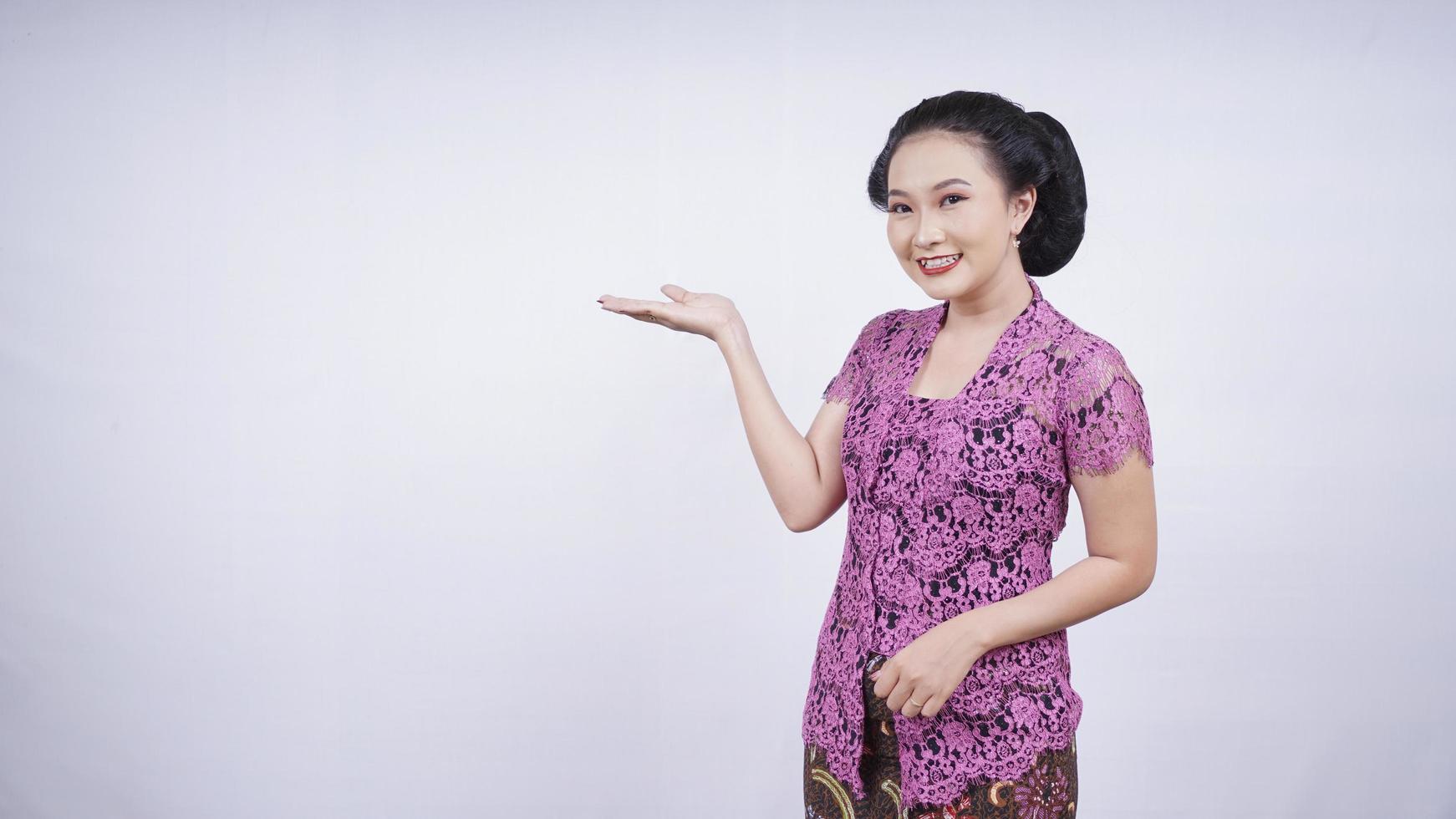 belleza en kebaya sonriendo apuntando en blanco hacia los lados aislado sobre fondo blanco foto