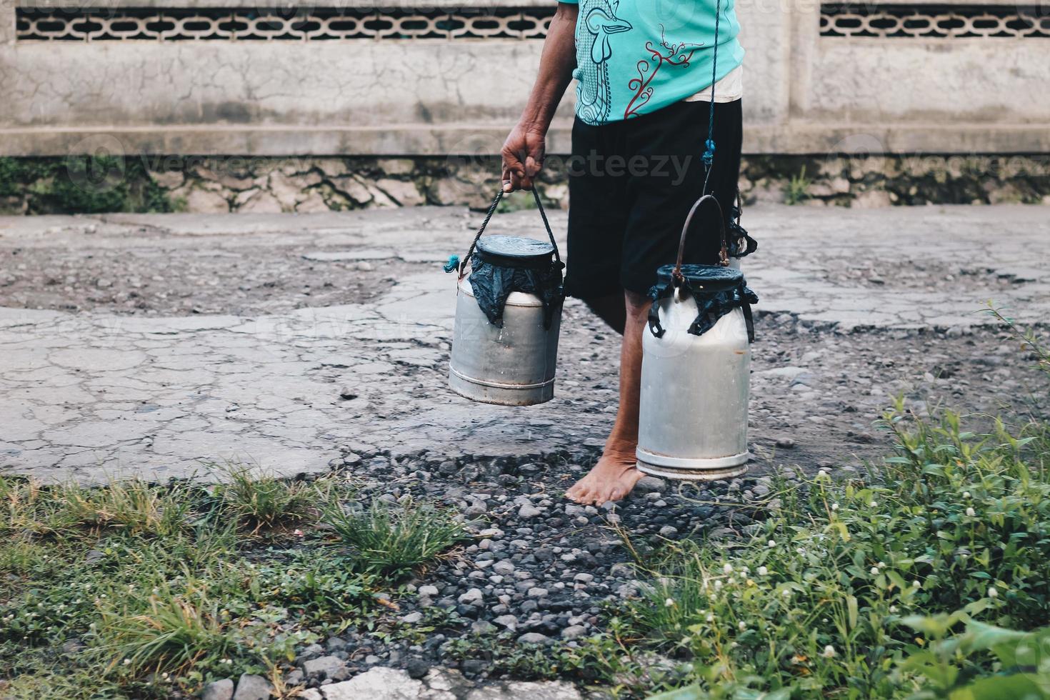 Traditional dairy worker or Milk man in Boyolali, Indonesia bring Metal Shiny Milk Container or kettle Traditional Can from traditional farm photo