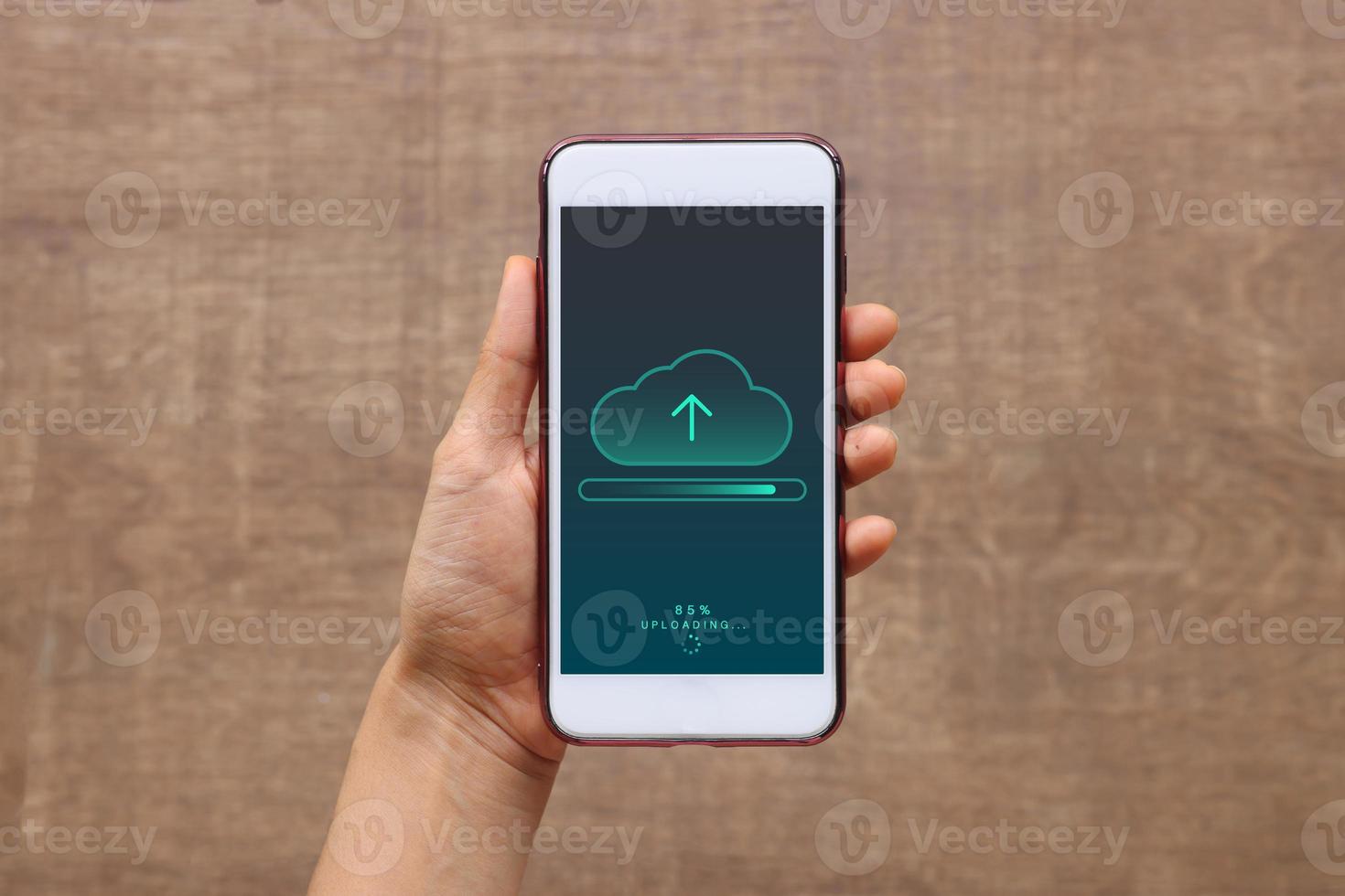 Smartphone on hand opening cloud uploading concept on phone screen. woman or man hand upload from mobile phone to store data on server photo