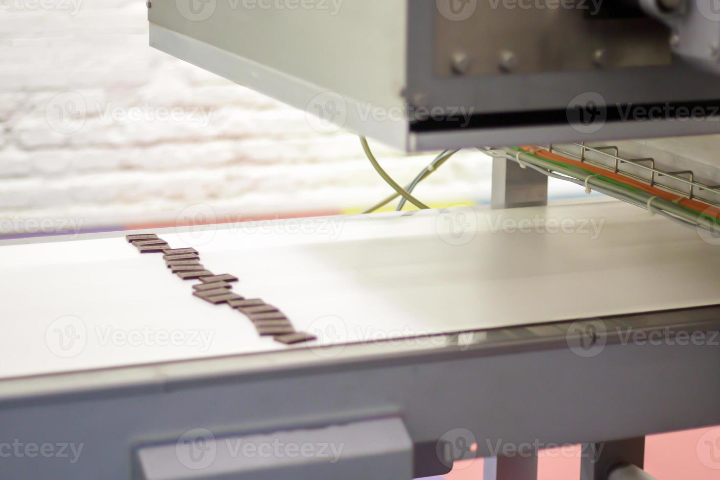 Line for the production of chocolate in an industrial factory. Automatic process in the production line of sweets. Images from the chocolate factory during production. Conveyor belt with sweets. photo