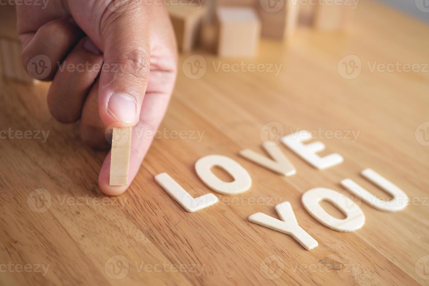 These words mean I LOVE U in wood plates. The square blocks use for background elements. Valentine's day concept. photo