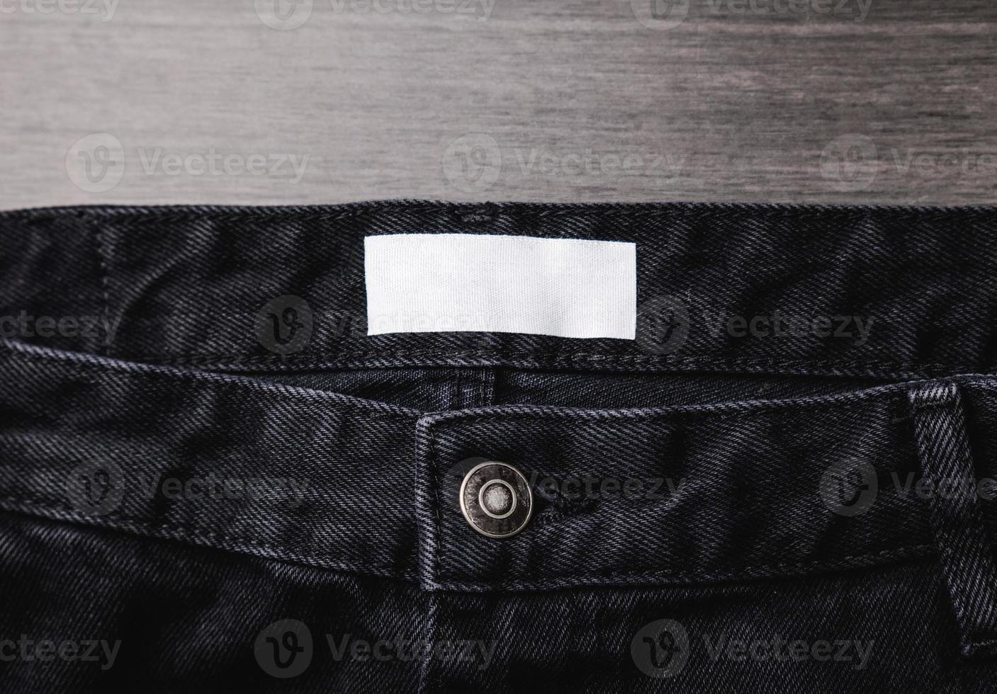 Blank clothing label on denim jeans texture. Label with empty space for text photo