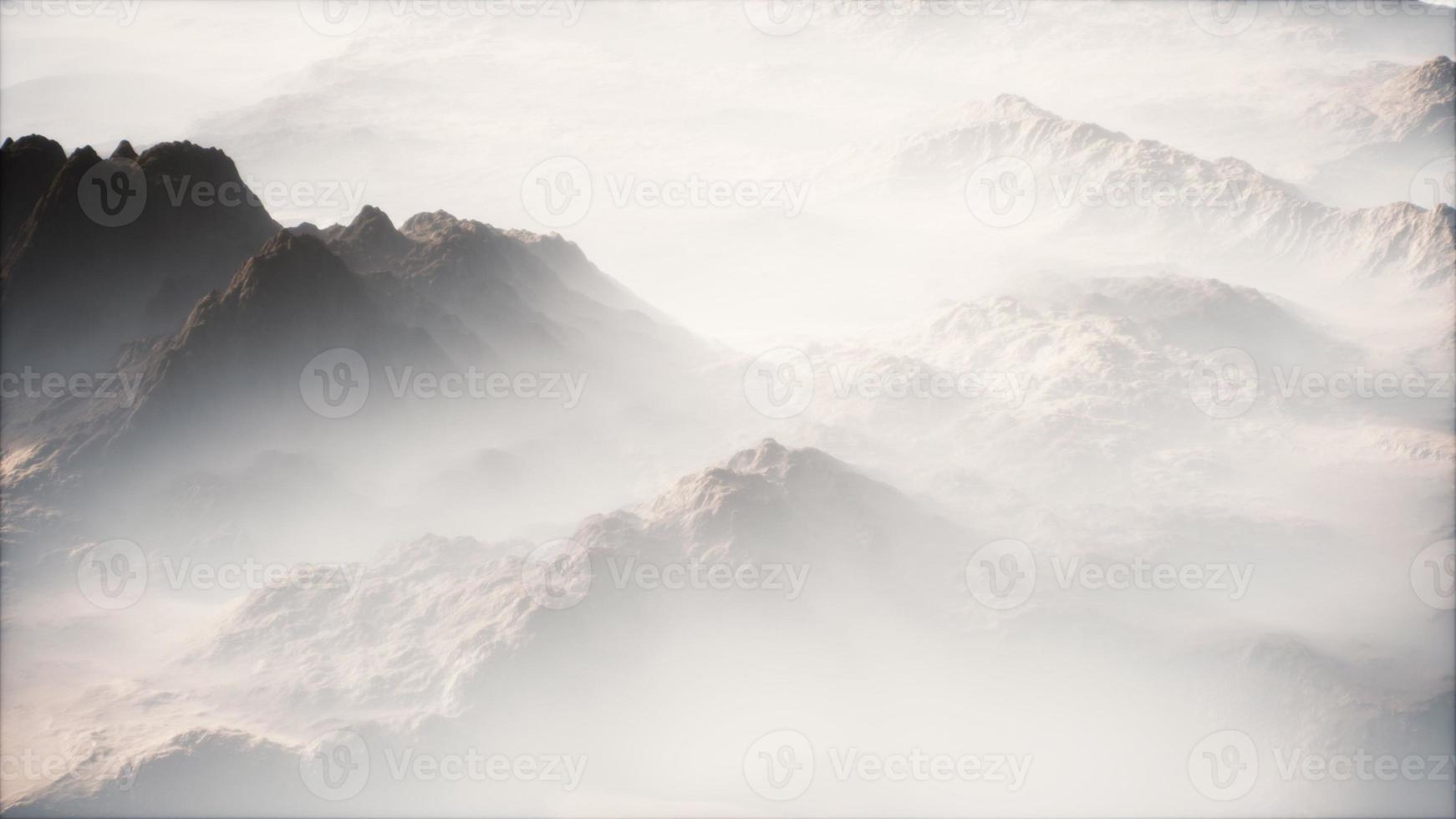 Distant mountain range and thin layer of fog on the valleys photo