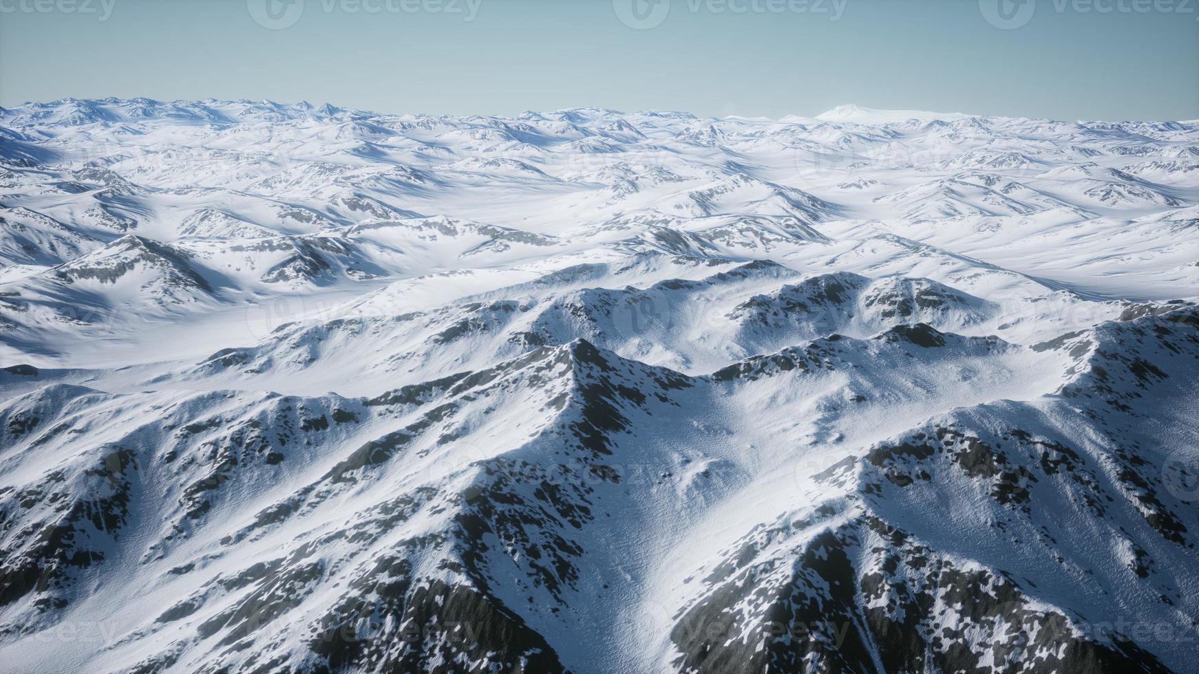 8K Aerial Landscape of snowy mountains and icy shores in Antarctica photo