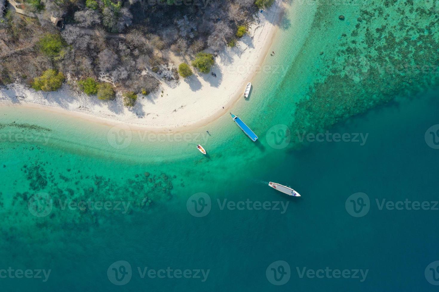 vista aérea de hermosas aguas claras y playa blanca con botes en verano de isla tropical foto