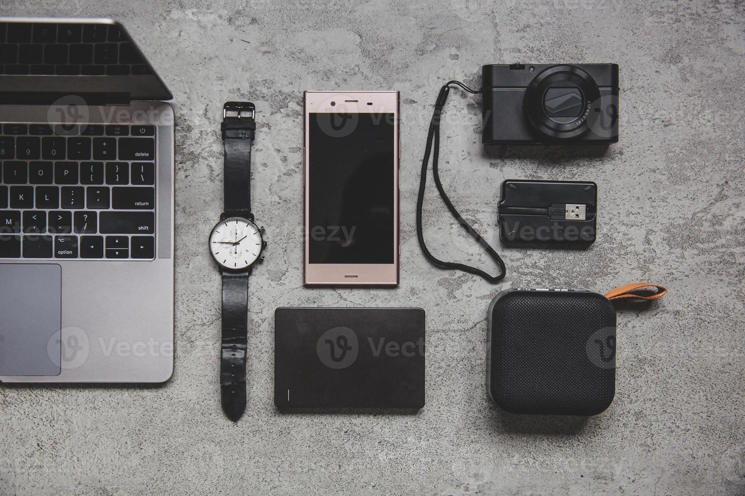 Flat lay top view of work concept with computer laptop and travel accessories on grey concrete wall photo