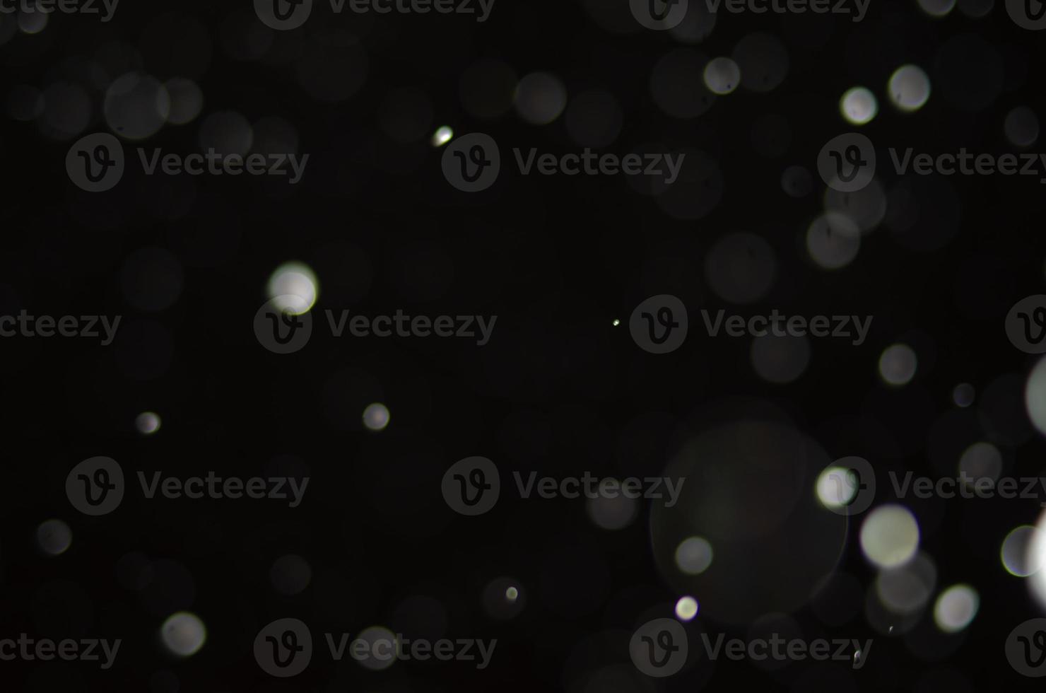 Nighttime falling snow with a bokeh effect against a background of city lights. photo