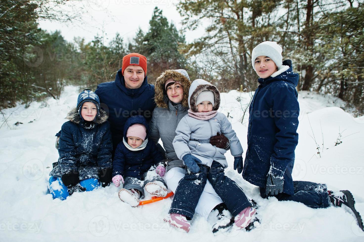 Father and mother with four children in winter nature. Outdoors in snow. photo