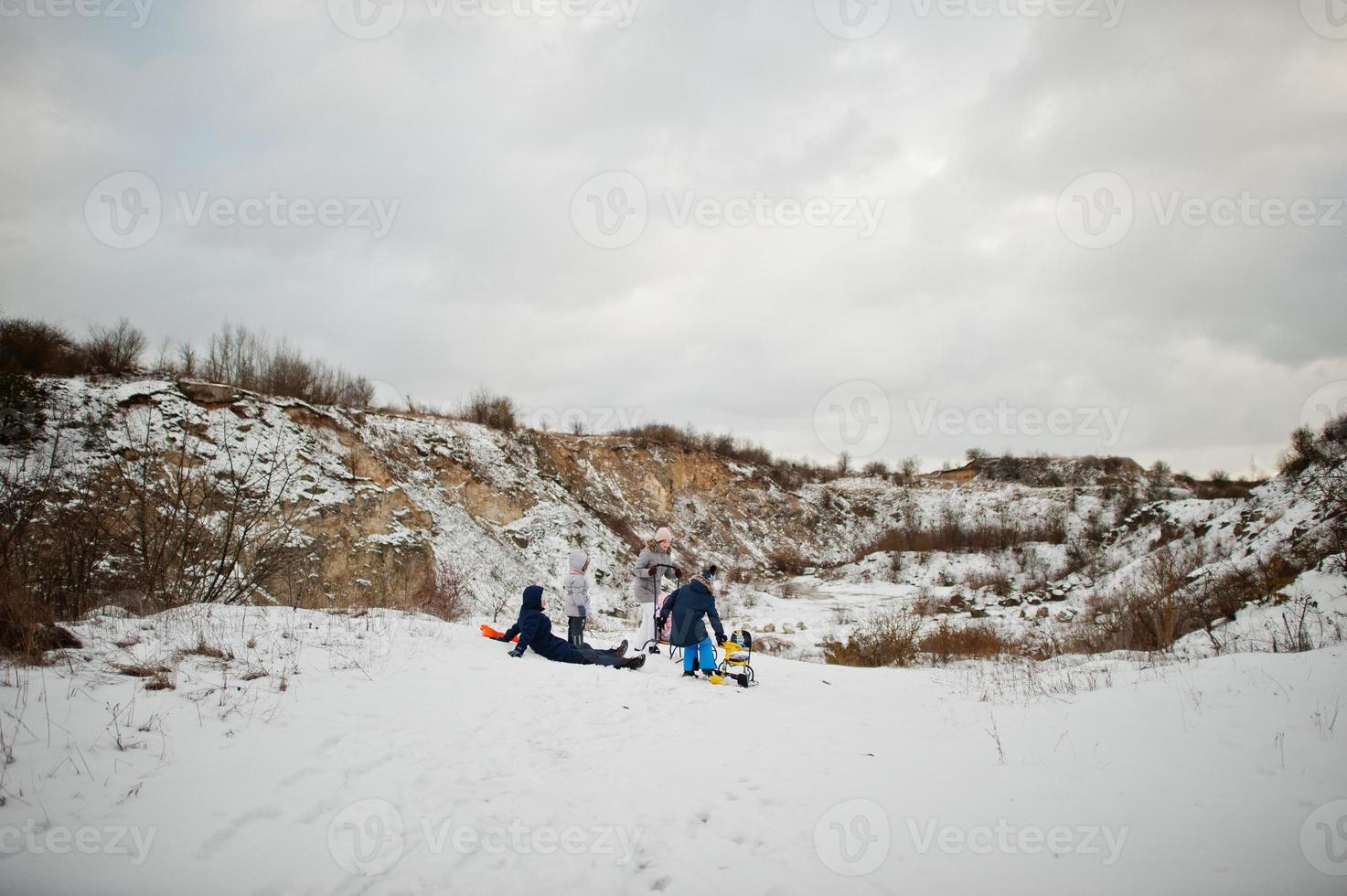 Family plays and sleigh rides in winter outdoor, mother and children having fun. photo