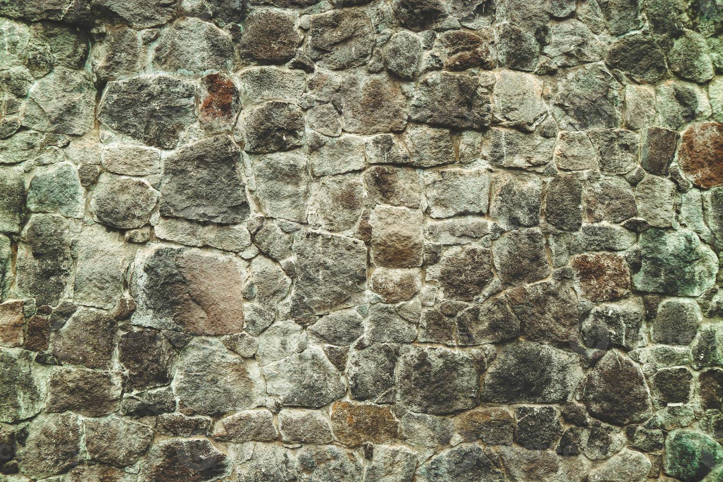 Abstract traditional stone wall pavement texture background. Bumpy textured stonewall made from flagstone and slabstone. photo