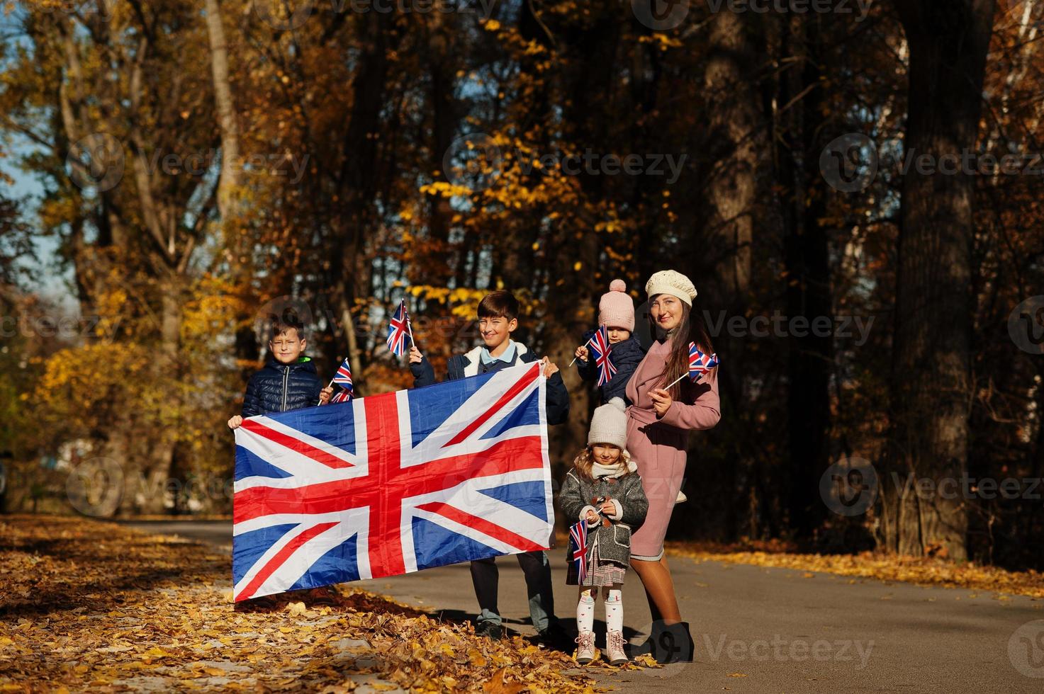 fiesta nacional del reino unido. familia con banderas británicas en el parque de otoño. britanicidad celebrando el Reino Unido. madre con cuatro hijos. foto