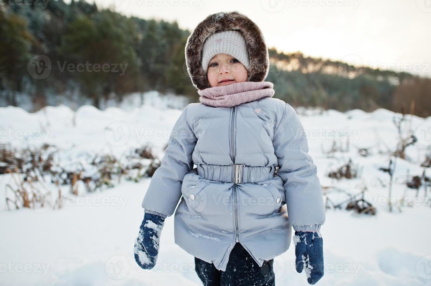 Baby girl in winter nature. Outdoors in snow. photo