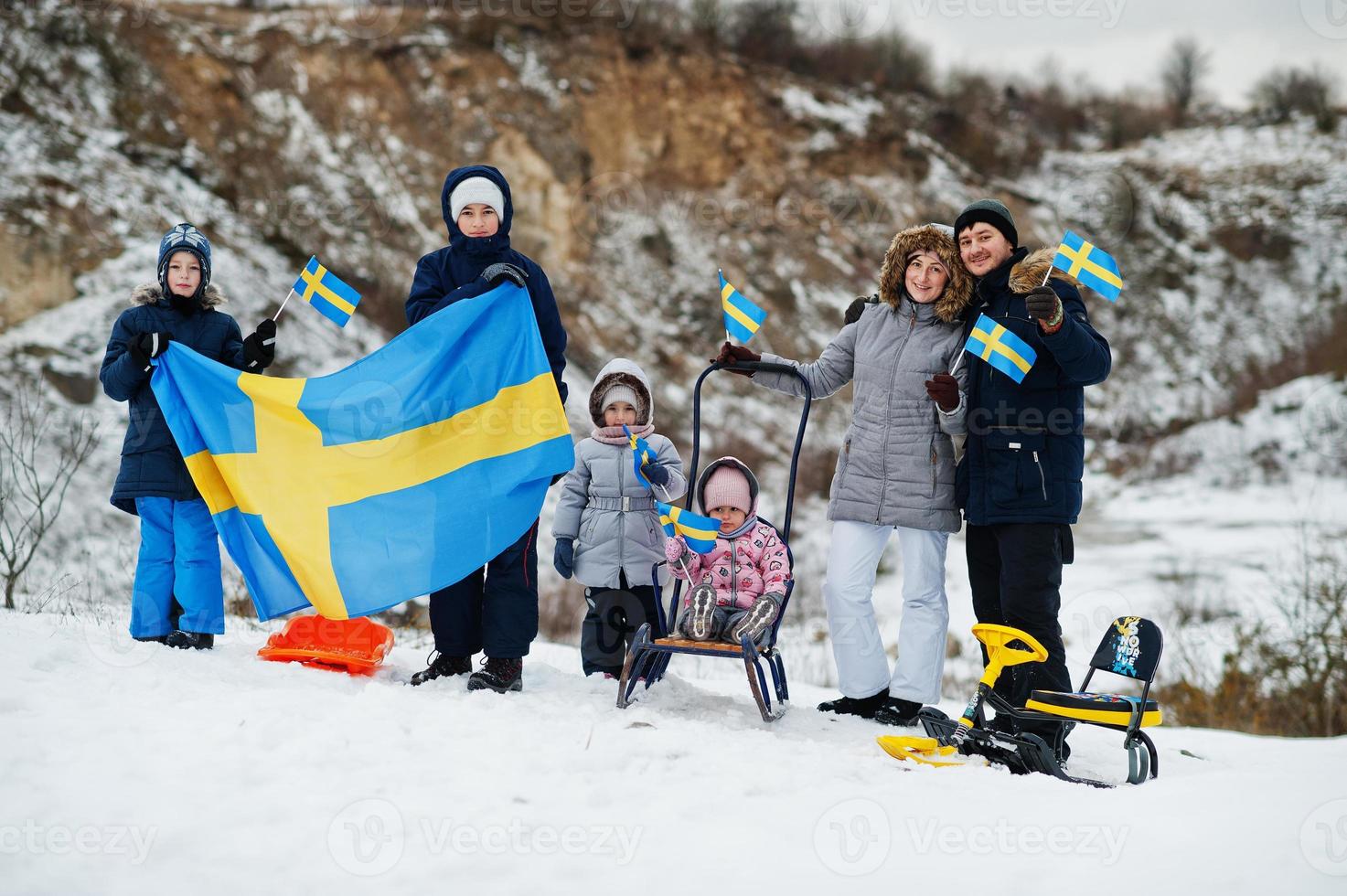 Scandinavian family with Sweden flag in winter swedish landscape